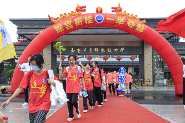 玉林市育輝高級中學紅毯鋪地，紅聯(lián)掛樓，為勇士出征高考助威祝福。在一片助威聲中，育園學子目光如炬，步伐堅定，意氣風發(fā)地邁過狀元門，斗志昂揚地出征高考。（陳穎強  周家名）.png